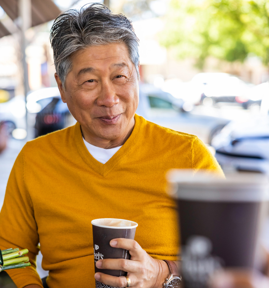 man smiling holding coffee