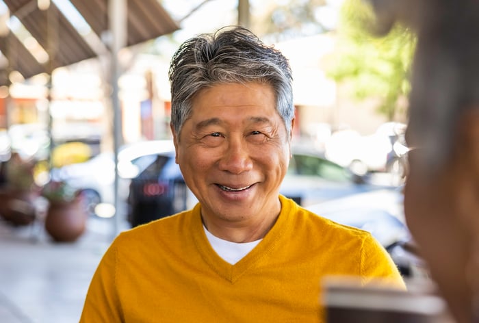 man smiling outside with friend