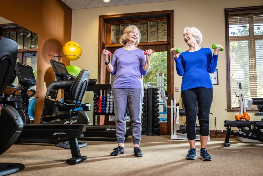 Two women lifting weights side by side