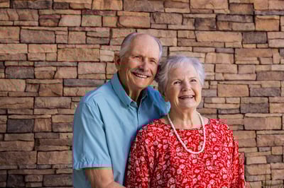Jeanne and Wayne posing together in front of a brick wall