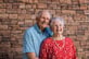 Jeanne and Wayne posing together in front of a brick wall