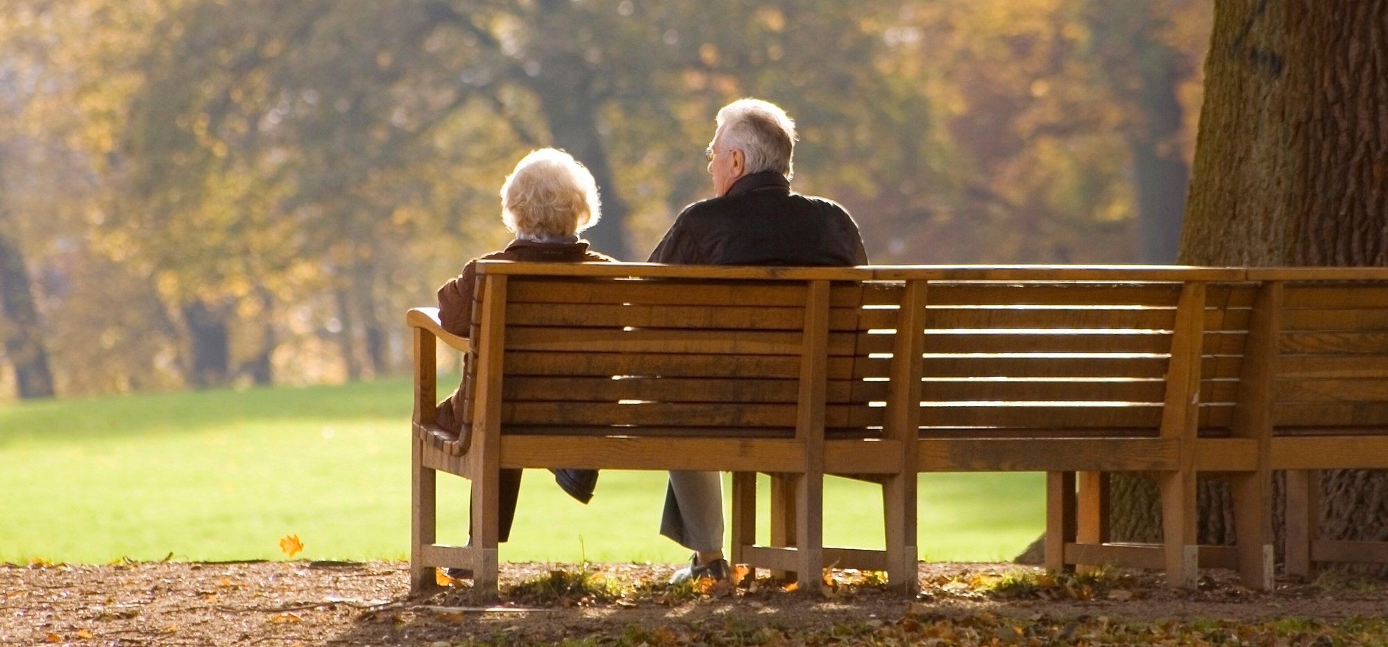 man and woman sitting side by side on a park bench