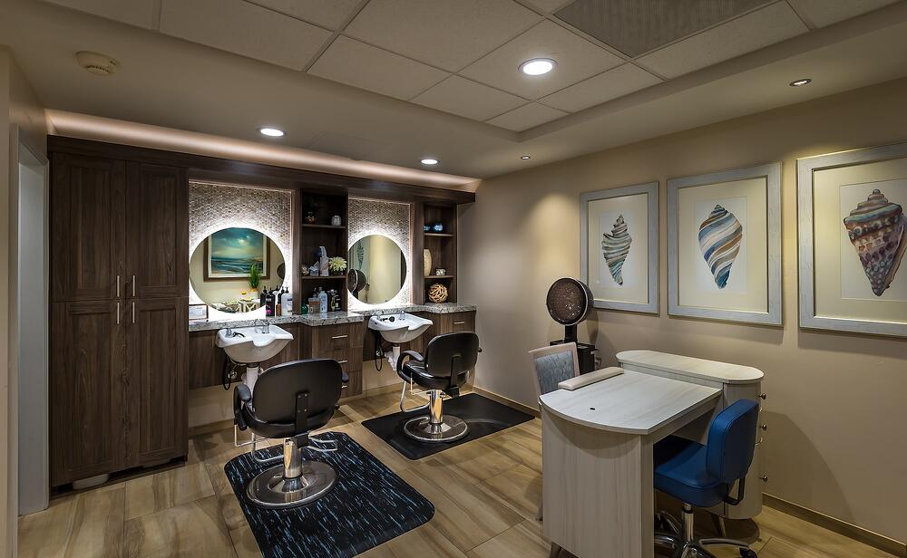 Modern barber shop with styling chairs, wash stations, and coastal decor.