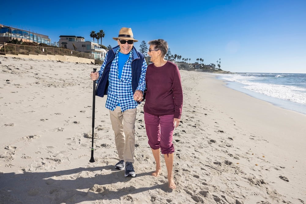 senior couple walking on the beach together