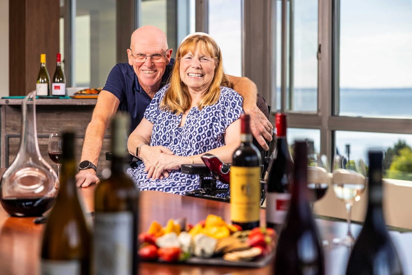 Residents smiling together at a table with wine and appetizers and scenic views at Judson Park, a HumanGood community.