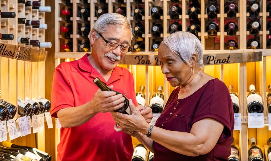 Seniors choosing a bottle of wine in a wine cellar