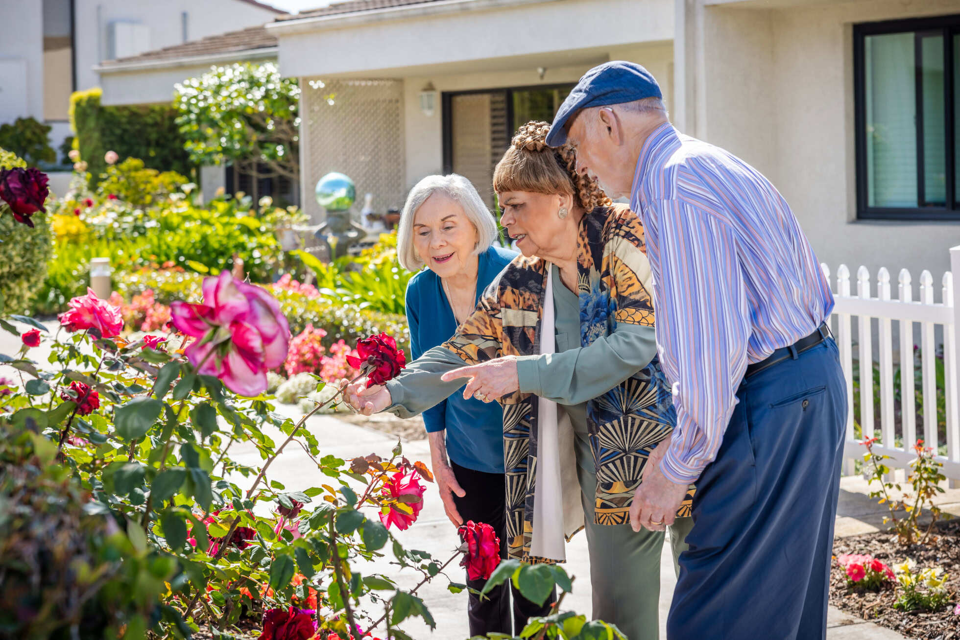 Three Regents Point residents looking at a flower garden