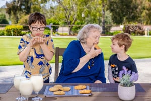 Woman eating cookies with her two grandchildren