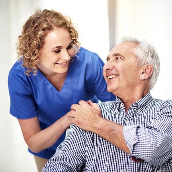 Female medical professional smiling at a senior man