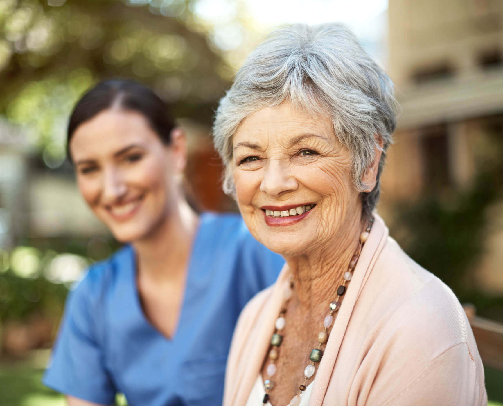 Senior woman and female nurse smiling