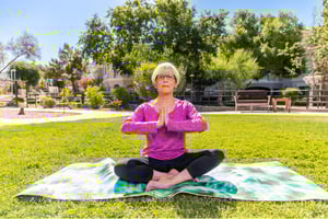 Senior lady holding a yoga pose outdoors