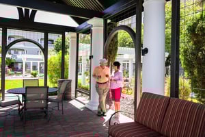 Senior couple standing under outdoor gazebo