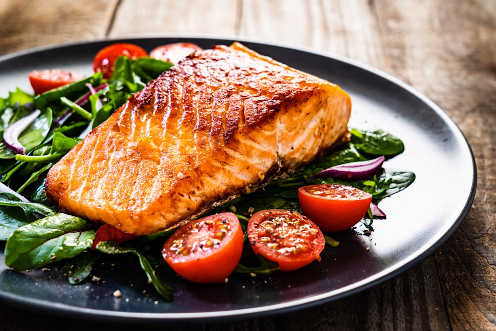 Pan-seared salmon on a bed of greens and tomatoes