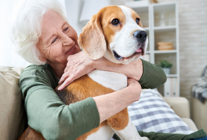 Senior woman hugging a dog