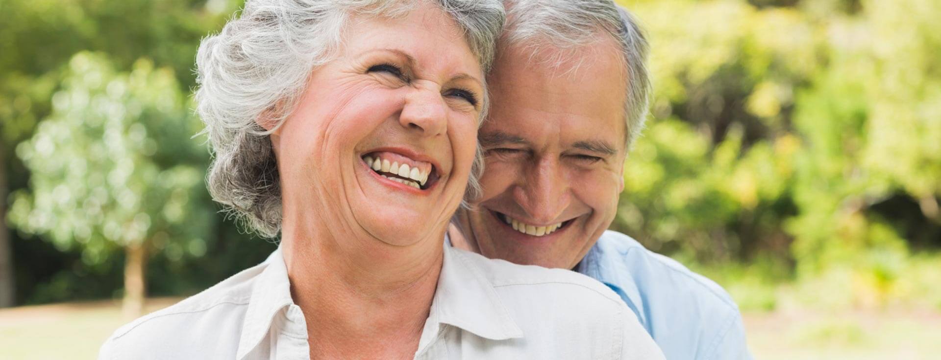 Senior couple smiling while hugging