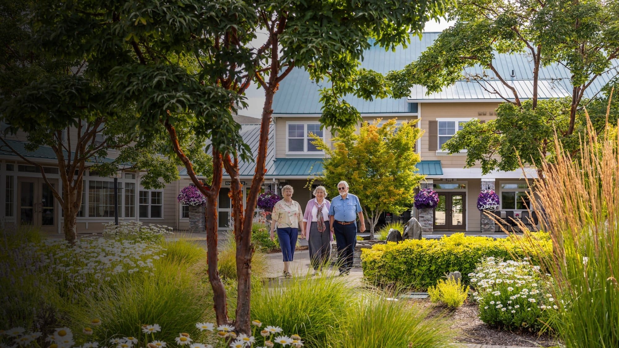 Three people walking through a garden path