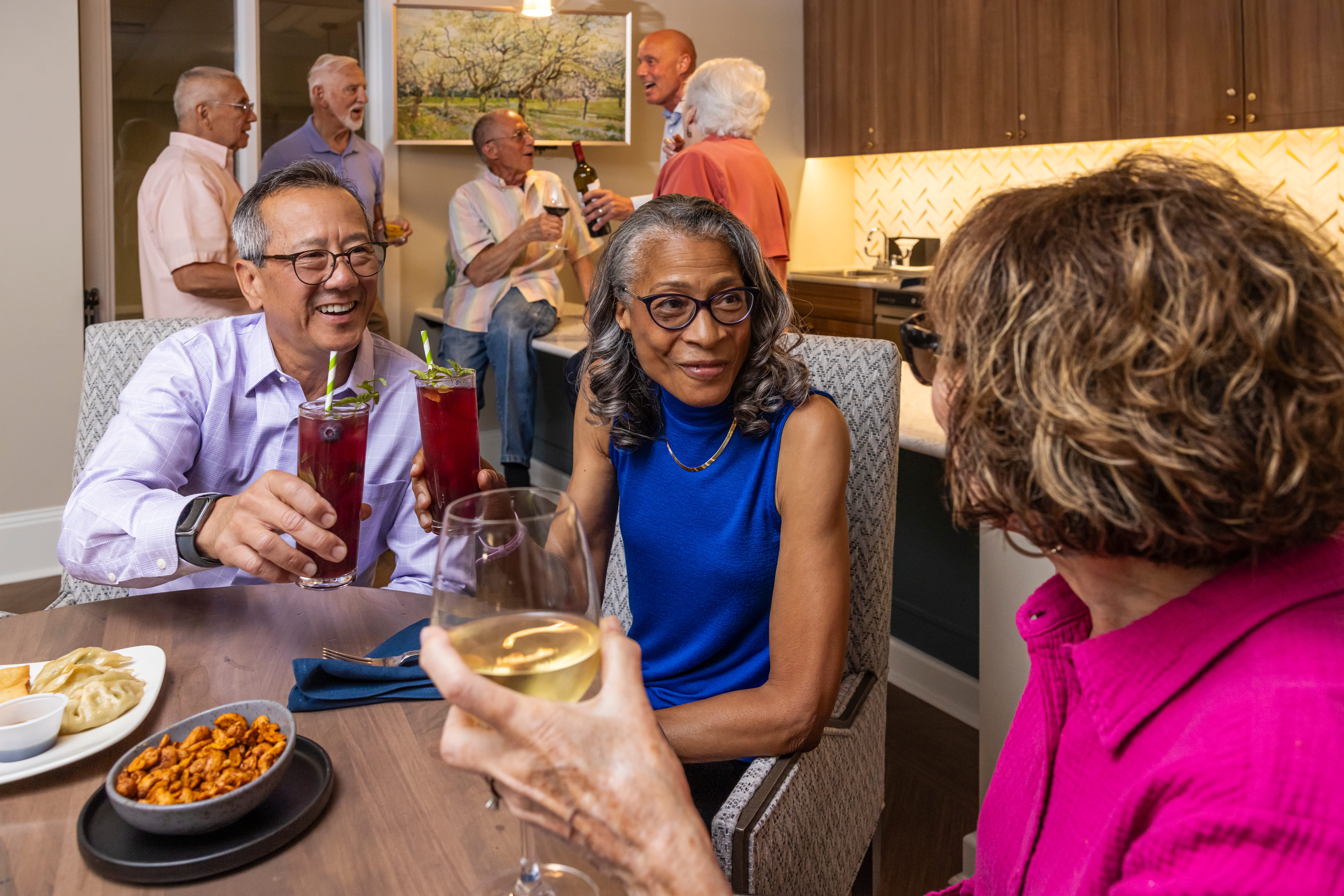 Seniors enjoying drinks, food, and conversation.