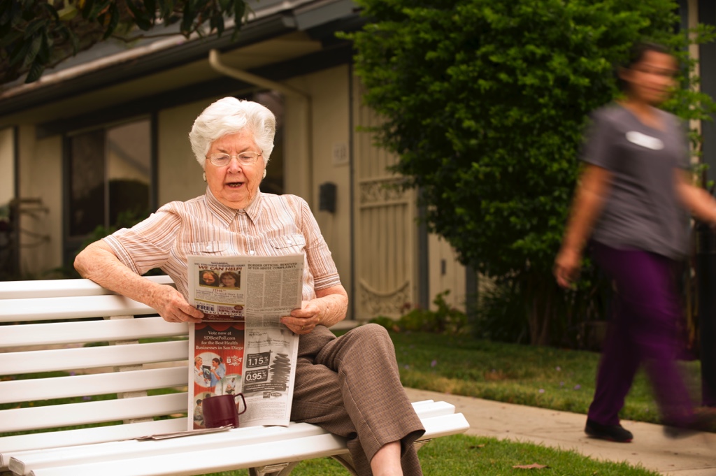 resident enjoying the outside reading a newspaper