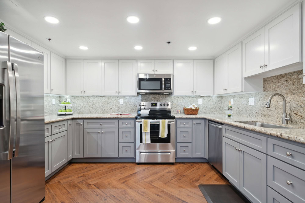 Kitchen with gray and white cabinets and a granite countertop