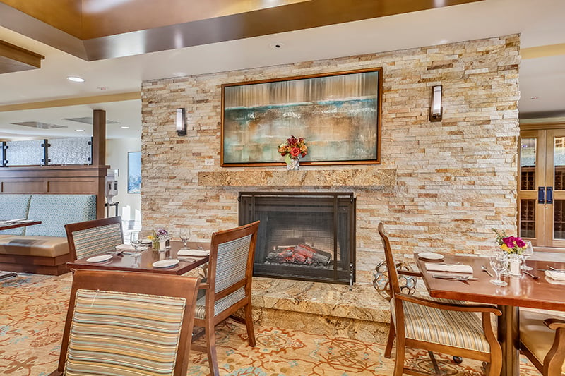 Dining area with a fireplace at senior living community The Terraces at Los Altos