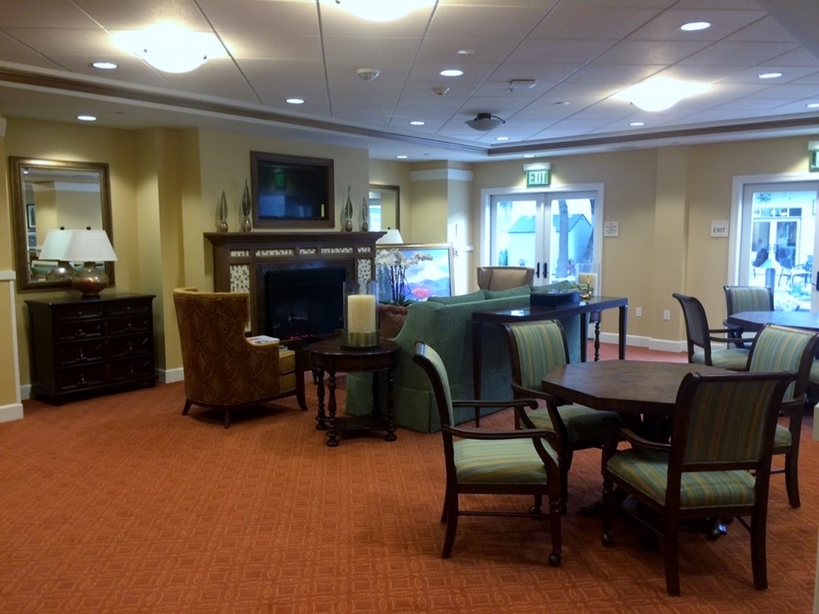 Common living room with a fireplace at The Terraces at Los Altos senior living community 