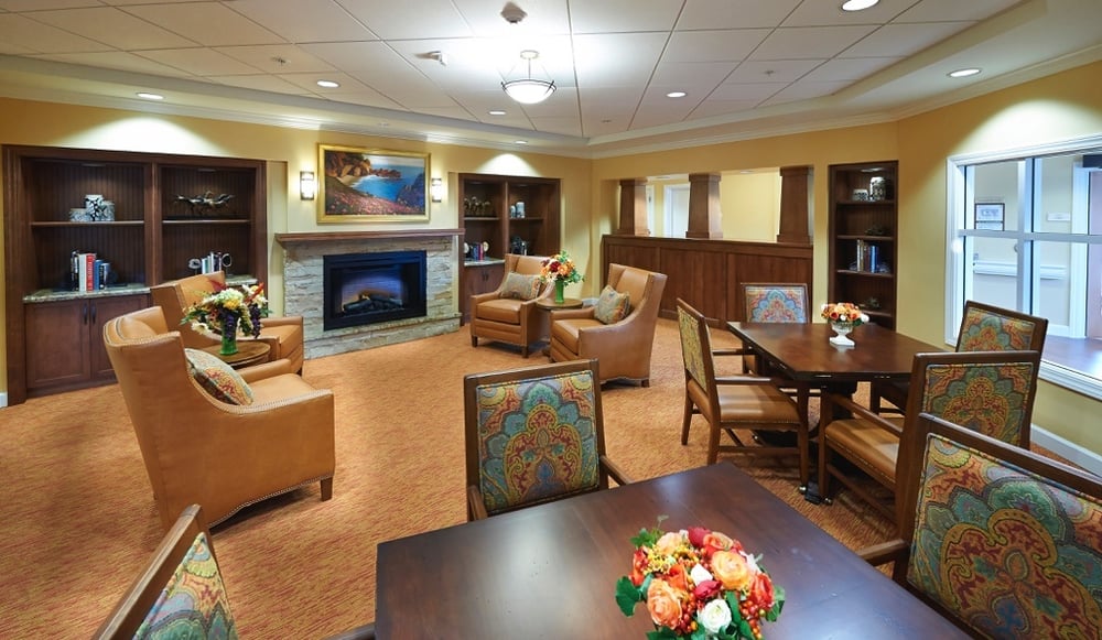 Common living room area with a fireplace at senior living community The Terraces at Los Altos