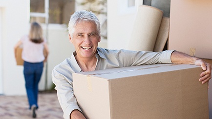 Couple moving boxes out of their home.