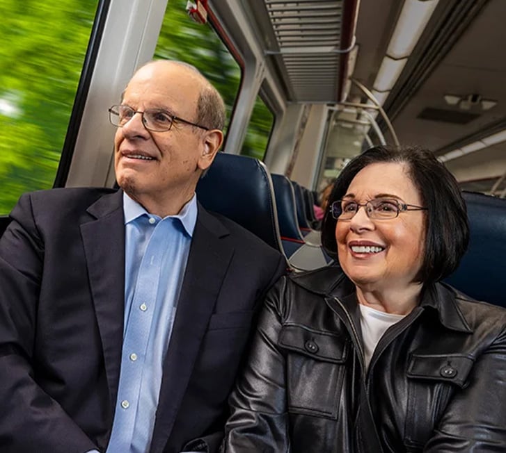Stan and Jackie sitting together on a bus