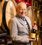 Karl holding a wine bottle while standing in a wine cellar