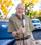Ron posing outside next to a car