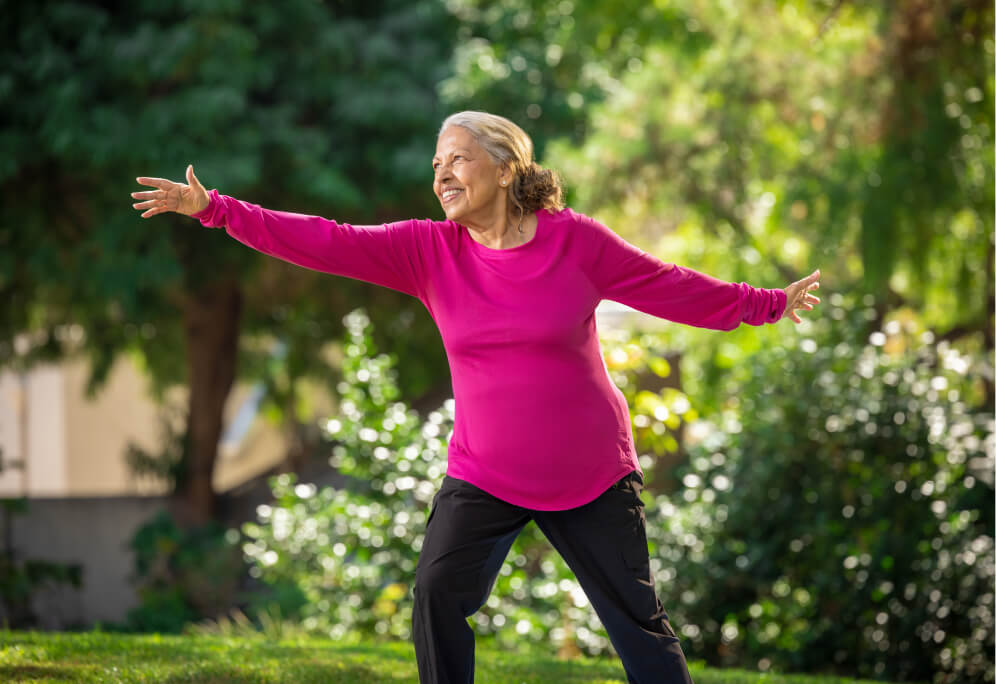 Hezla, a HumanGood resident, doing a yoga pose outside in the garden