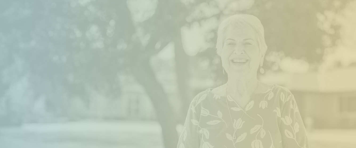 Smiling senior woman standing outside in a HumanGood Life Plan Community