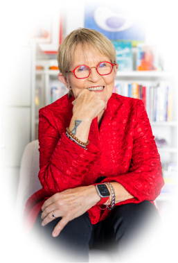 Sara B. Hart, a resident of The Terraces at Los Altos wearing a red shirt and red glasses