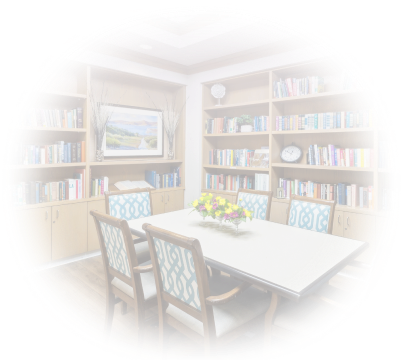 Bookshelves and a table and chairs in the library of a HumanGood Life Plan Community