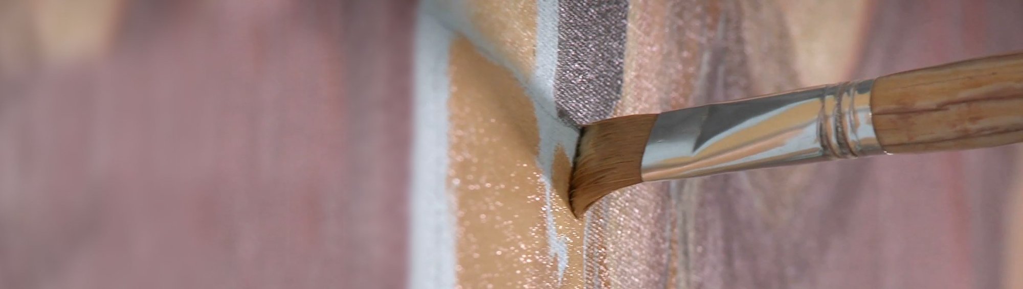 Close-up of a paintbrush with a dark yellow paint