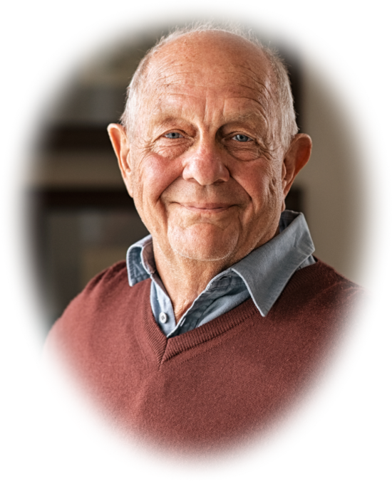 A smiling man looks toward the camera in a cozy indoor setting.