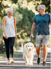 Man and woman walking their dog