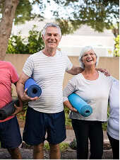 Man and woman holding yoga mats