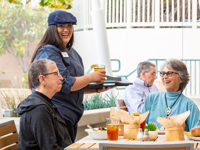 A waiter brings drinks to a table