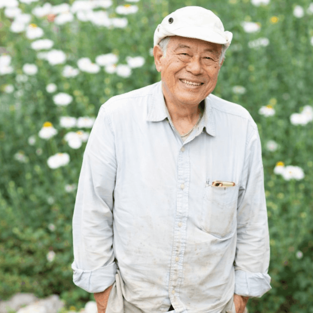 Smiling resident named Danny standing outdoors among flowers.