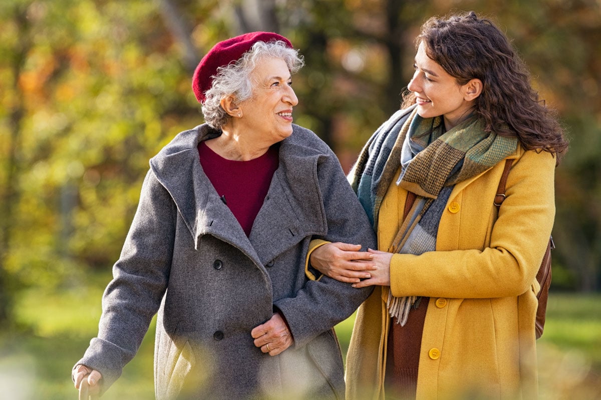 Senior woman walking with the assistance of her daughter