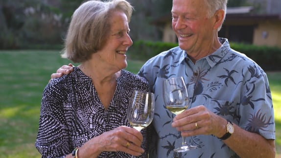Senior couple toasting while drinking wine
