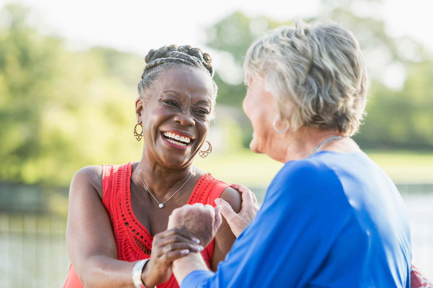 Residents share a joyful moment outdoors, highlighting connection, warmth, and vibrant community living.