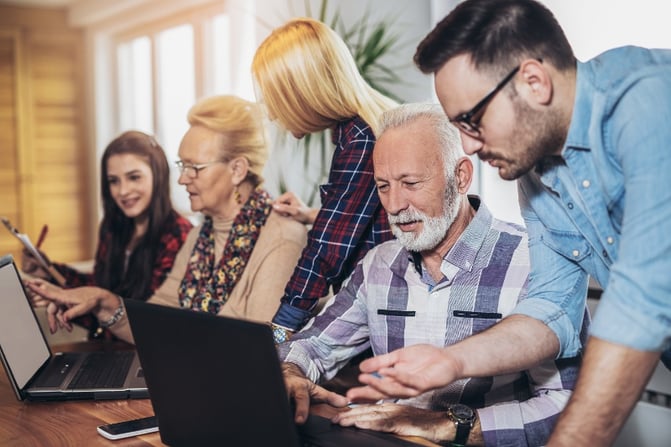 Young people helping seniors with their laptops. 