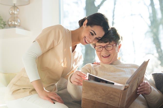 A nurse looking at a photo album with a senior resident.