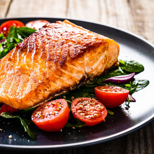 pan-seared salmon on a bed of greens and tomatoes