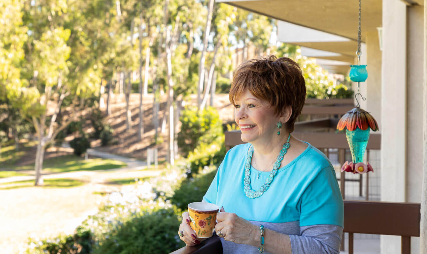 Senior woman enjoying a cup of tea on the balcony of her apartment at Regents Point