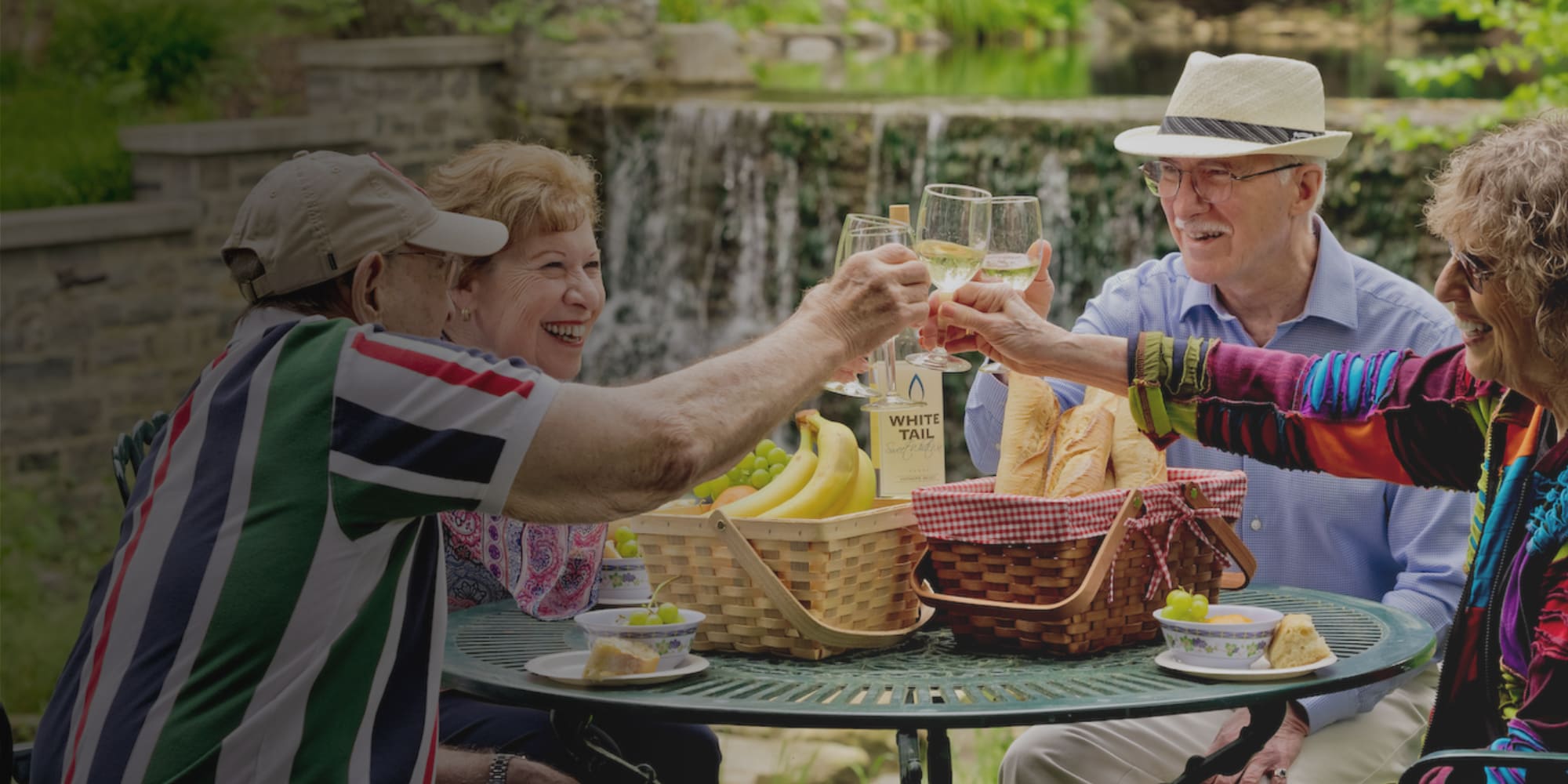 Four people drinking wine together outside