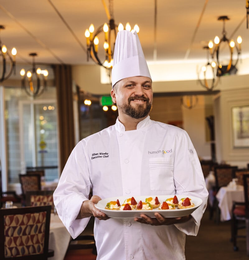 Executive chef of a HumanGood Life Plan Community holding a plate of food