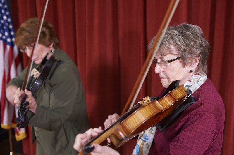 Two senior women playing violins